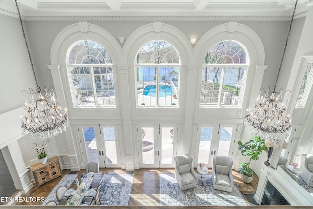 sunroom with a wealth of natural light, french doors, and a chandelier