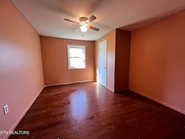 unfurnished room with dark wood-type flooring and ceiling fan