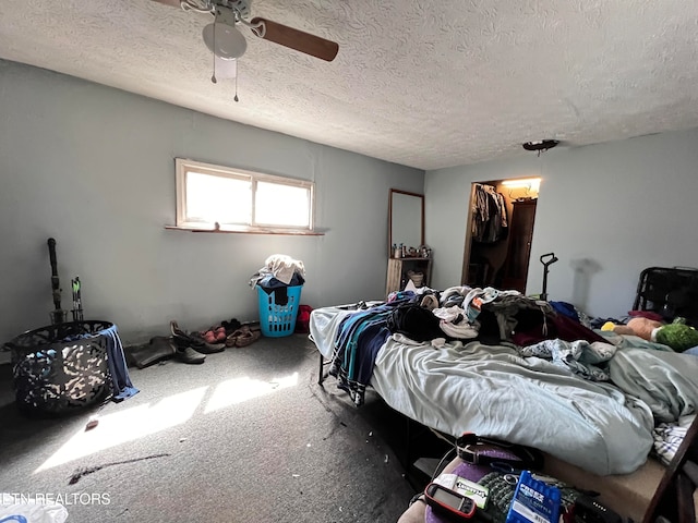 bedroom with carpet, ceiling fan, a textured ceiling, a spacious closet, and a closet