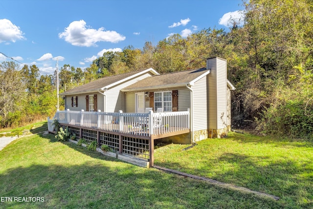 view of front of property with a wooden deck and a front lawn