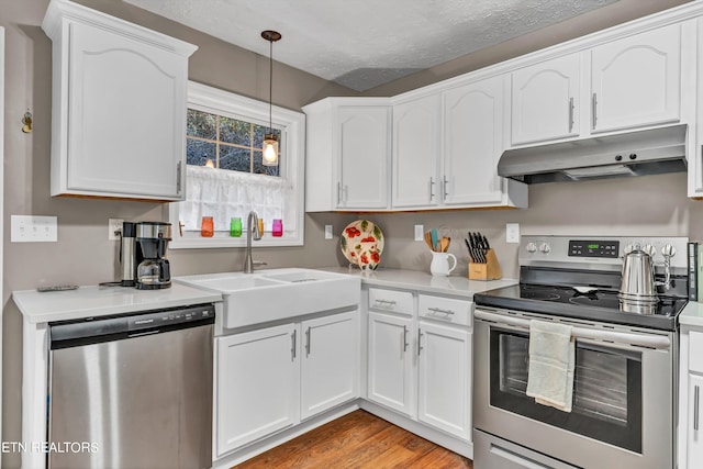 kitchen with white cabinetry, stainless steel appliances, a textured ceiling, and sink