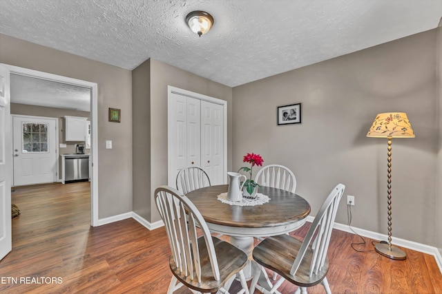 dining room featuring a textured ceiling and dark hardwood / wood-style flooring