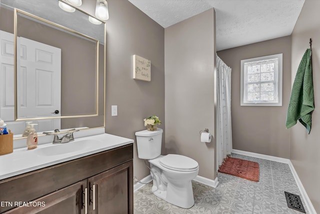 bathroom with vanity, a textured ceiling, and toilet