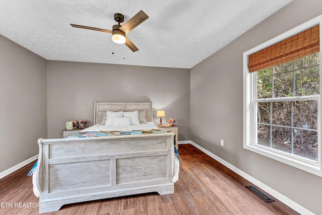 unfurnished bedroom featuring a textured ceiling, hardwood / wood-style flooring, and ceiling fan