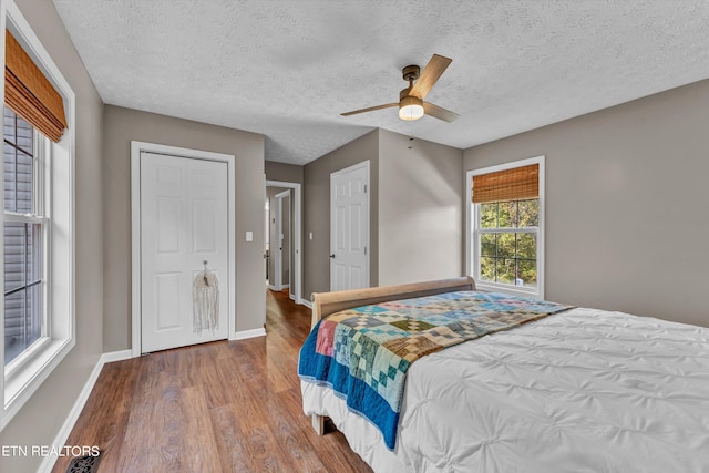 bedroom featuring a textured ceiling, wood-type flooring, and ceiling fan