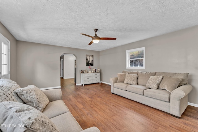 living room with hardwood / wood-style floors, a textured ceiling, and ceiling fan