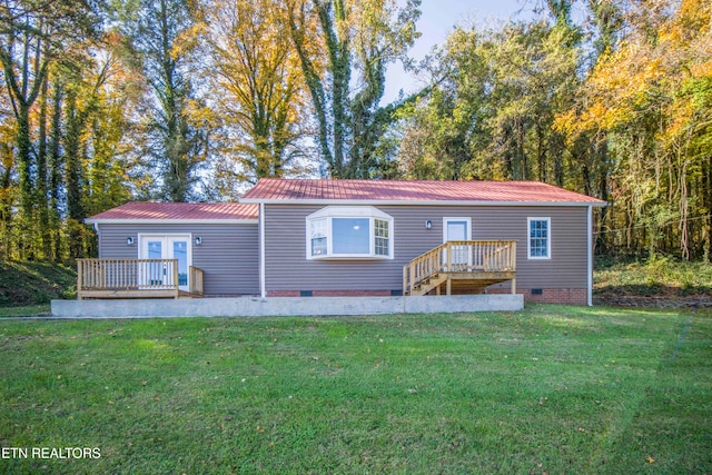 back of house featuring a wooden deck and a yard