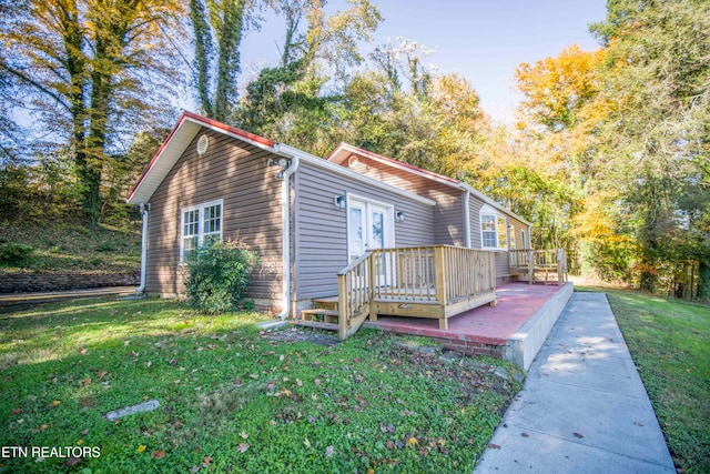 view of front of property with a front yard and a deck