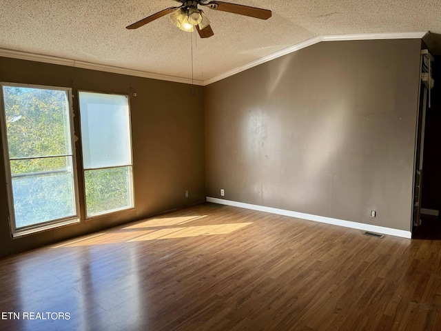 spare room featuring lofted ceiling, ceiling fan, a textured ceiling, wood-type flooring, and crown molding