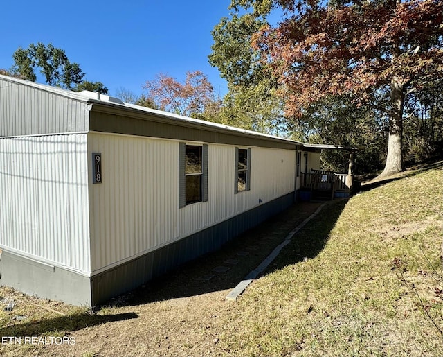 view of side of home with a yard