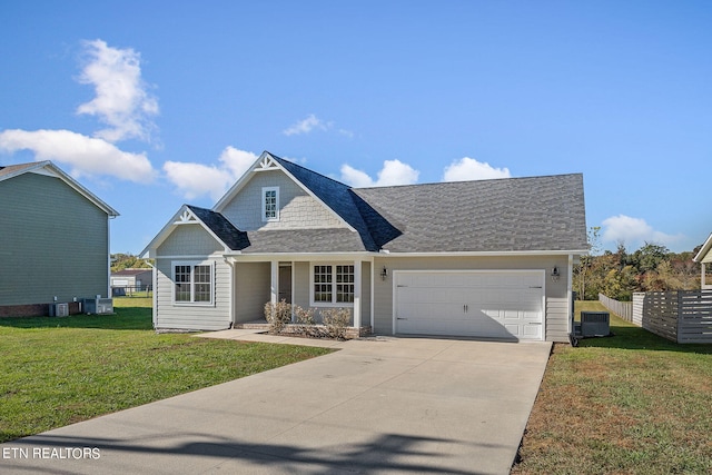 view of front of house with a front yard, a garage, and central air condition unit