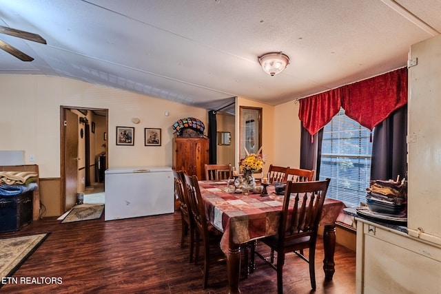 dining space with lofted ceiling, dark hardwood / wood-style floors, a textured ceiling, and ceiling fan