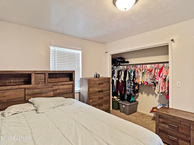 carpeted bedroom with a textured ceiling and a closet