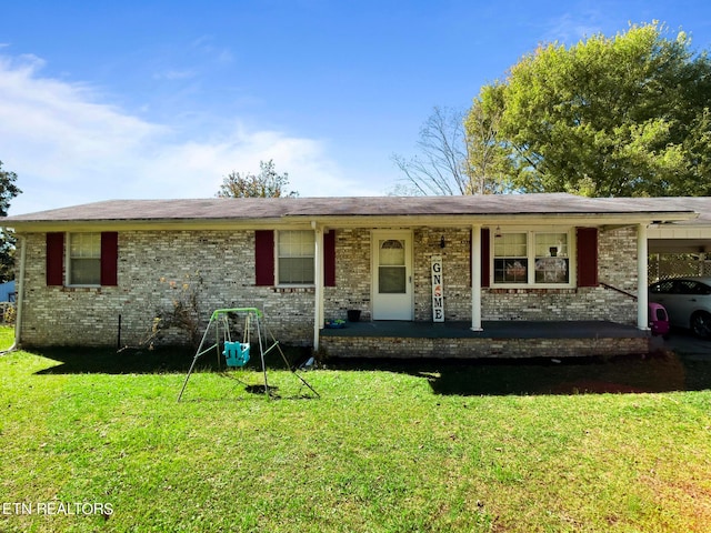 ranch-style home featuring a porch, a front lawn, and a carport