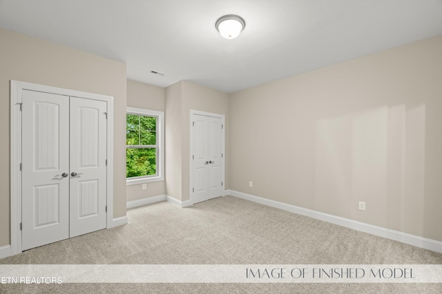 unfurnished bedroom featuring a closet and light colored carpet