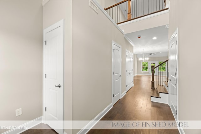 entrance foyer featuring a towering ceiling, a notable chandelier, and wood-type flooring