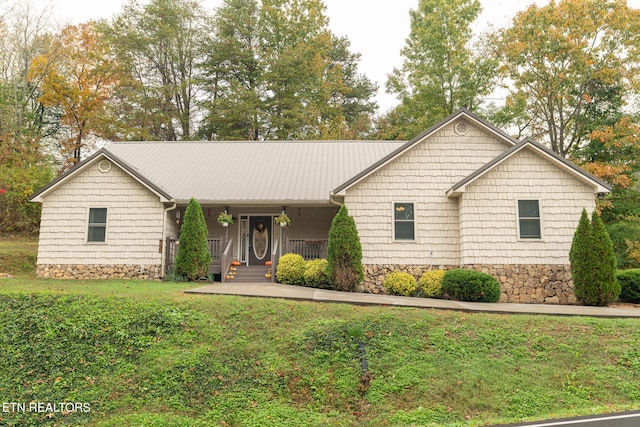 ranch-style house with a front yard and covered porch