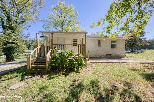 back of property featuring a lawn