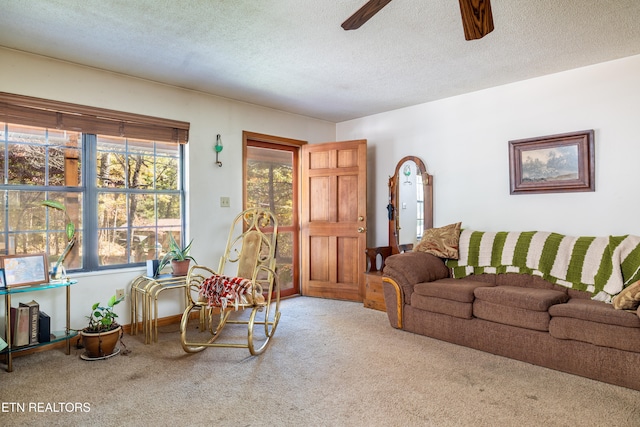 carpeted living room with a textured ceiling and ceiling fan