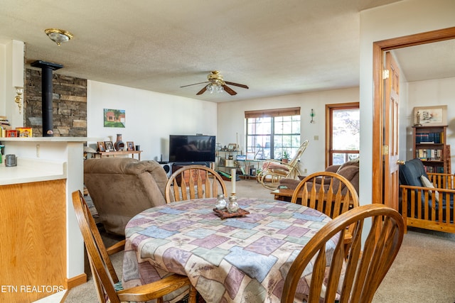 dining area with a textured ceiling, carpet flooring, and ceiling fan