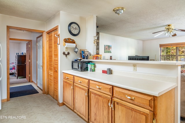 kitchen with ceiling fan and a textured ceiling