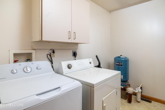 laundry room with washer and dryer and cabinets