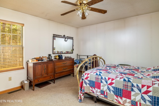 carpeted bedroom with a textured ceiling and ceiling fan