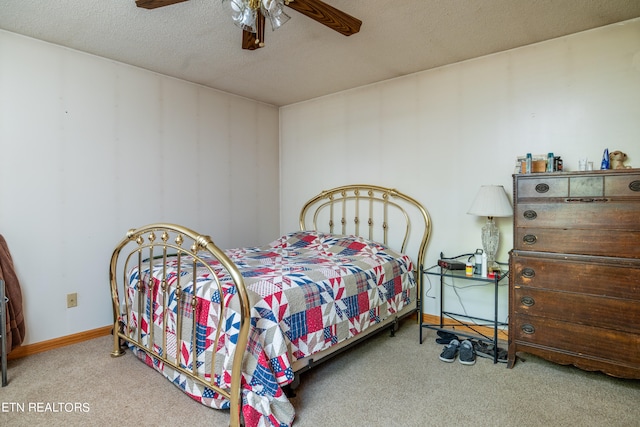 bedroom featuring a textured ceiling, light colored carpet, and ceiling fan