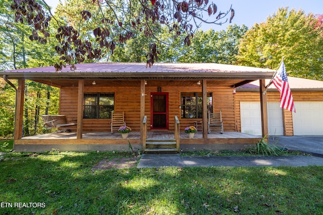 log home with a front lawn, covered porch, and a garage