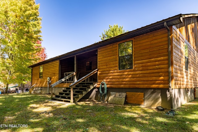 rear view of property featuring a lawn