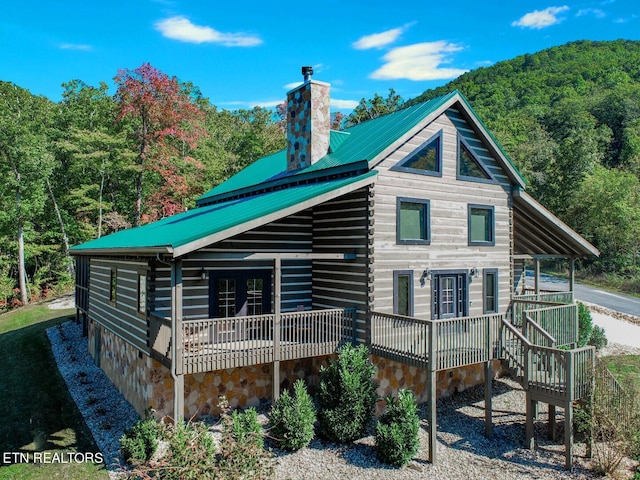 rear view of property featuring a wooden deck