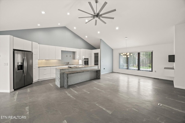 kitchen with ceiling fan with notable chandelier, stainless steel appliances, pendant lighting, high vaulted ceiling, and white cabinetry