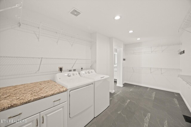 washroom with washer and clothes dryer and cabinets