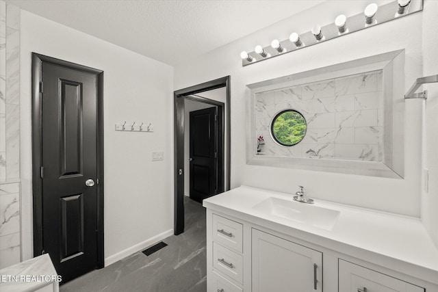 bathroom featuring a textured ceiling and vanity