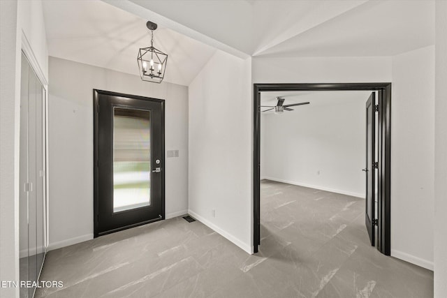 foyer with a chandelier and vaulted ceiling