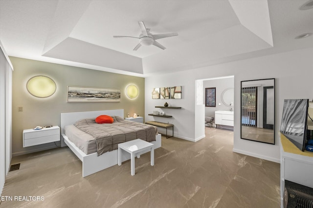 bedroom featuring connected bathroom and a raised ceiling