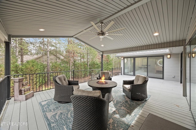 wooden terrace featuring ceiling fan and an outdoor fire pit