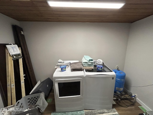 laundry area featuring wood ceiling, hardwood / wood-style flooring, and washing machine and dryer