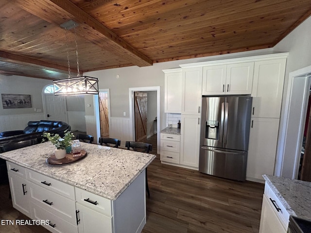 kitchen featuring appliances with stainless steel finishes, white cabinetry, dark hardwood / wood-style floors, beamed ceiling, and light stone counters