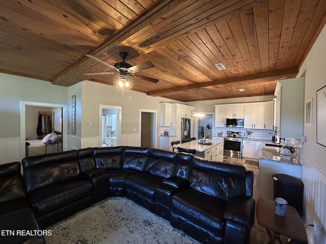 living room with wood ceiling, beam ceiling, and ceiling fan