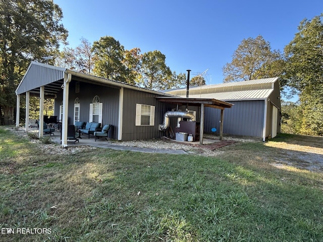 rear view of property with a yard and a patio area