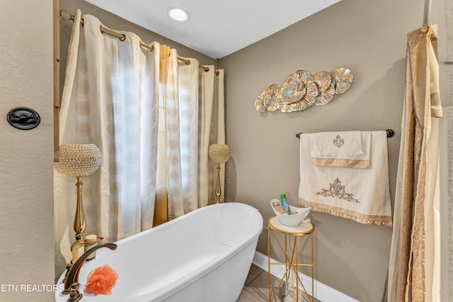 bathroom with a bathing tub and tile patterned floors