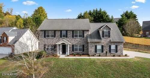 colonial home with stone siding and a front yard