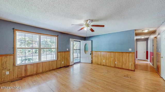 2732 Cherry Fork Rd, Helenwood, TN 37755 - empty room featuring a ceiling fan, wood walls, a textured ceiling, wainscoting, and wood finished floors