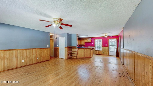 2732 Cherry Fork Rd, Helenwood, TN 37755 - unfurnished living room with light wood finished floors, a textured ceiling, ceiling fan, and wainscoting