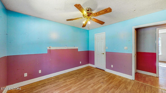 unfurnished room featuring a textured ceiling, hardwood / wood-style flooring, and ceiling fan