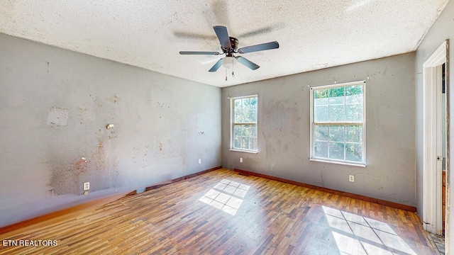 unfurnished room featuring ceiling fan, wood-type flooring, and a textured ceiling