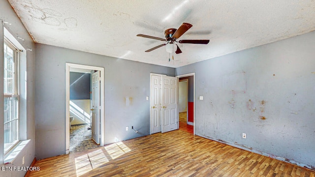 unfurnished bedroom featuring light hardwood / wood-style flooring, a textured ceiling, and ceiling fan