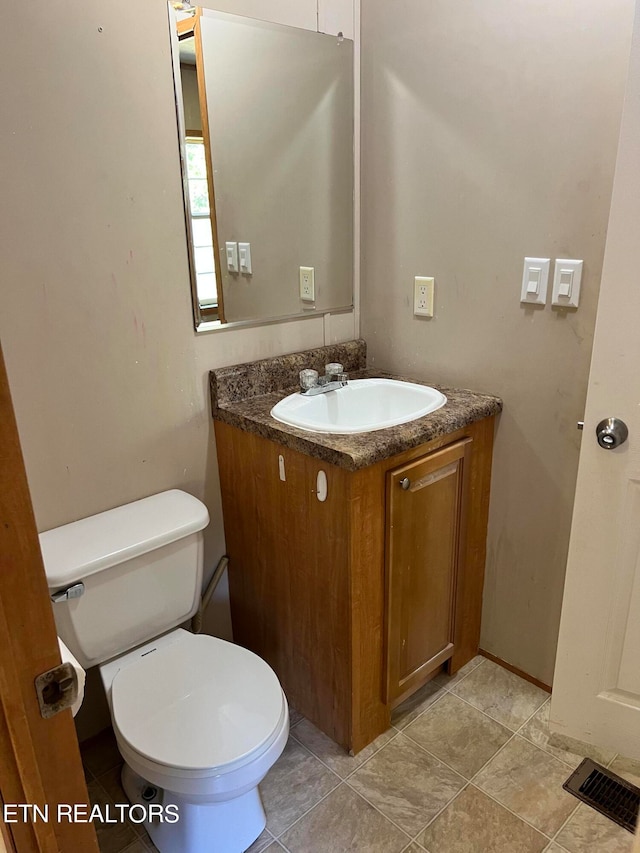 bathroom featuring vanity, toilet, and tile patterned flooring