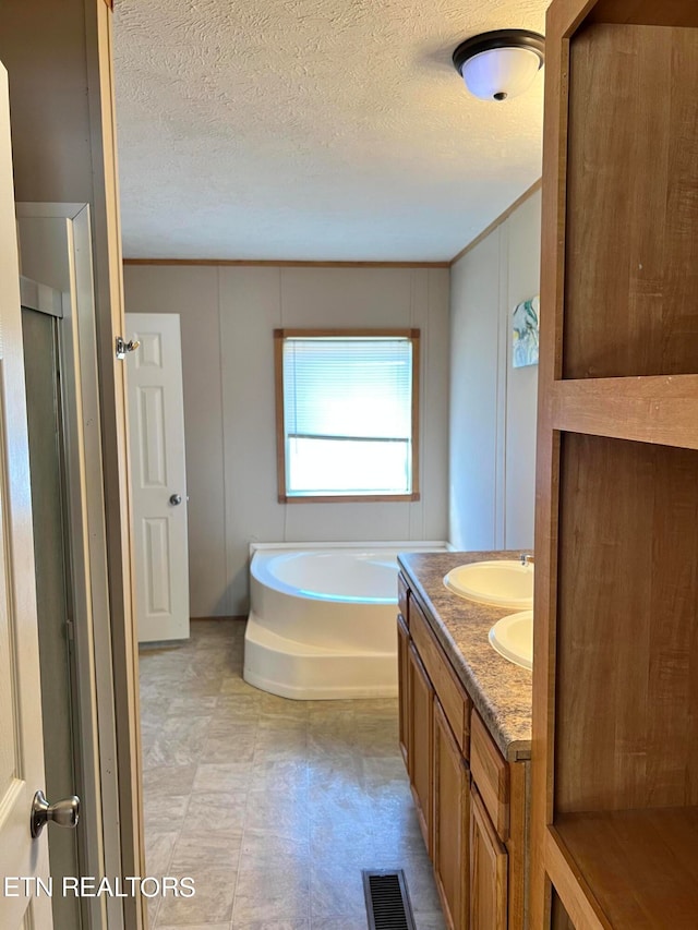 bathroom with vanity, crown molding, a textured ceiling, and shower with separate bathtub